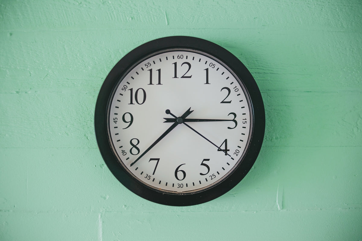 black and white analog wall clock at 10 00