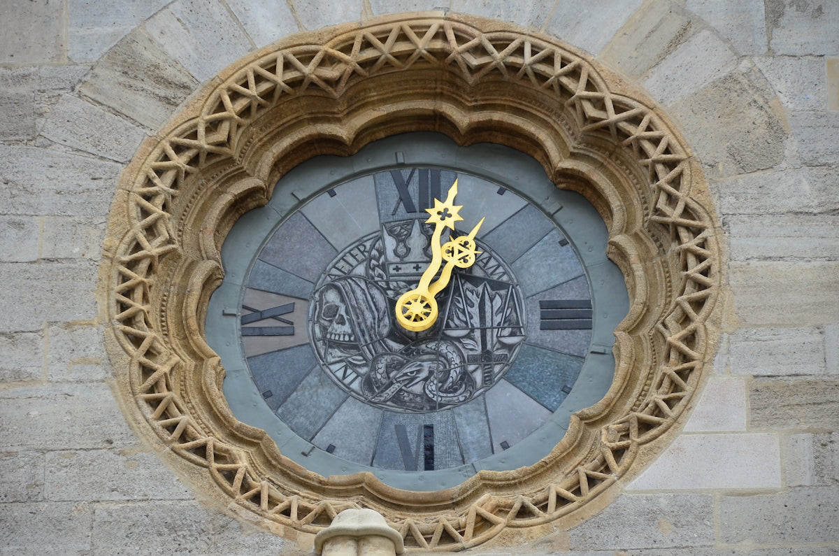 a clock on the side of a building with roman numerals