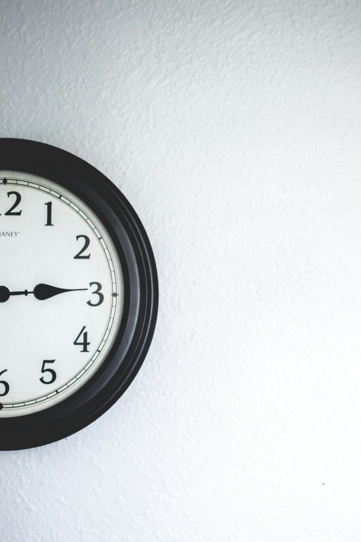 a black and white clock on a white wall