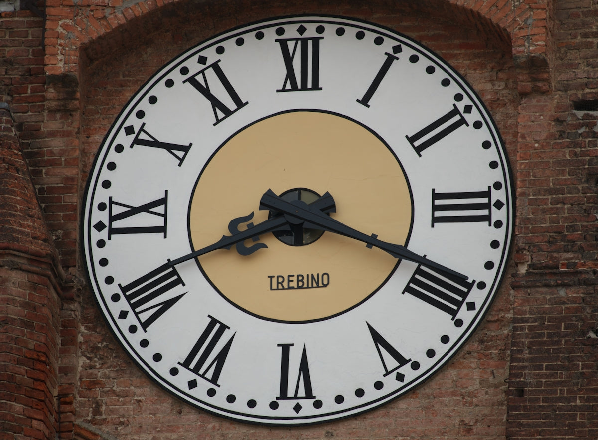 A clock with roman numerals on a brick wall