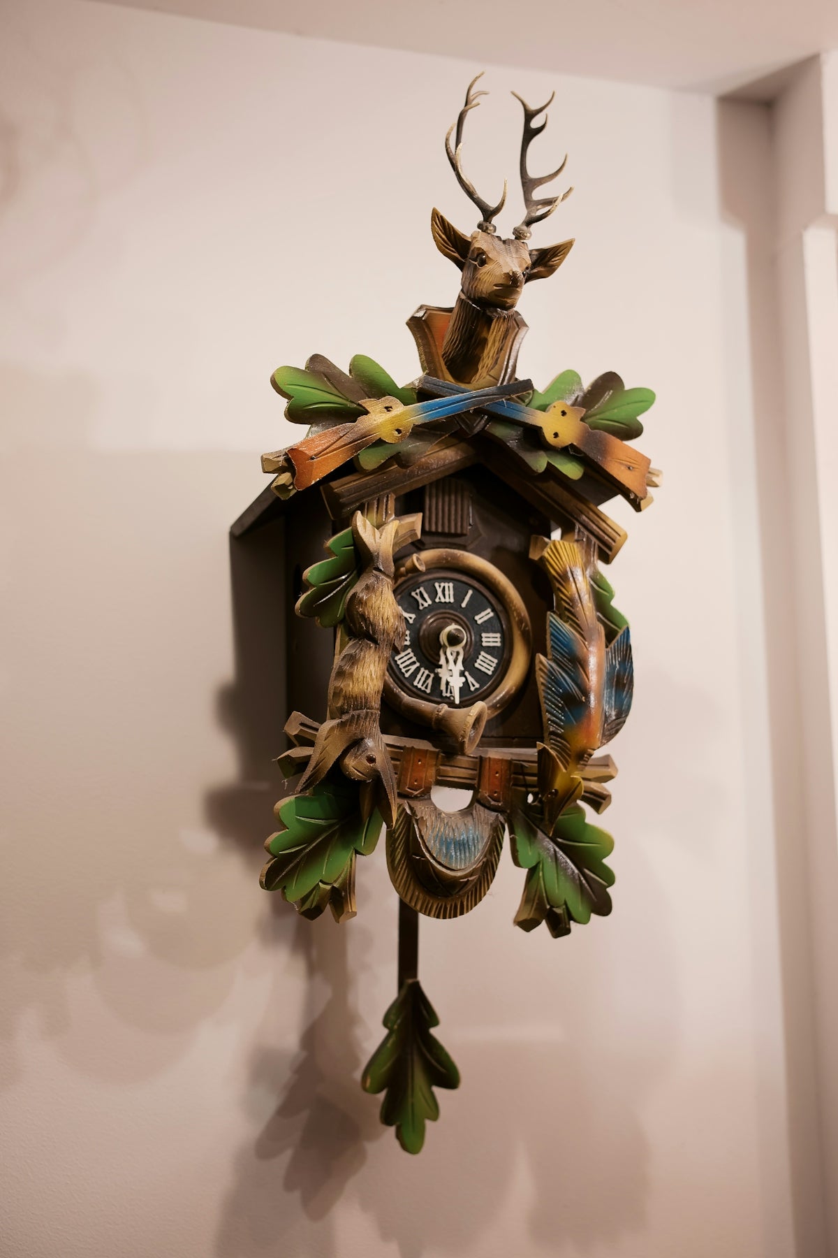 A cuckoo clock with a deer head and antlers on it