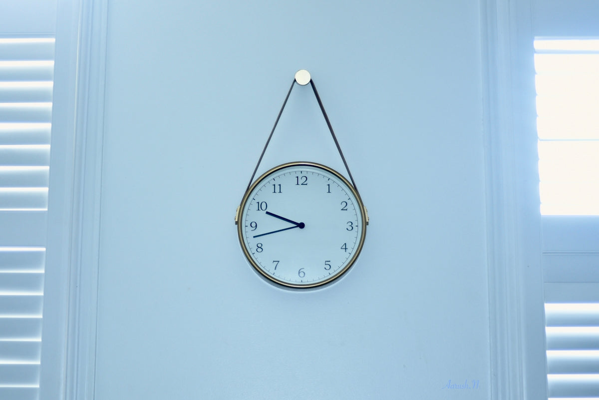 A clock hangs on a blue wall.