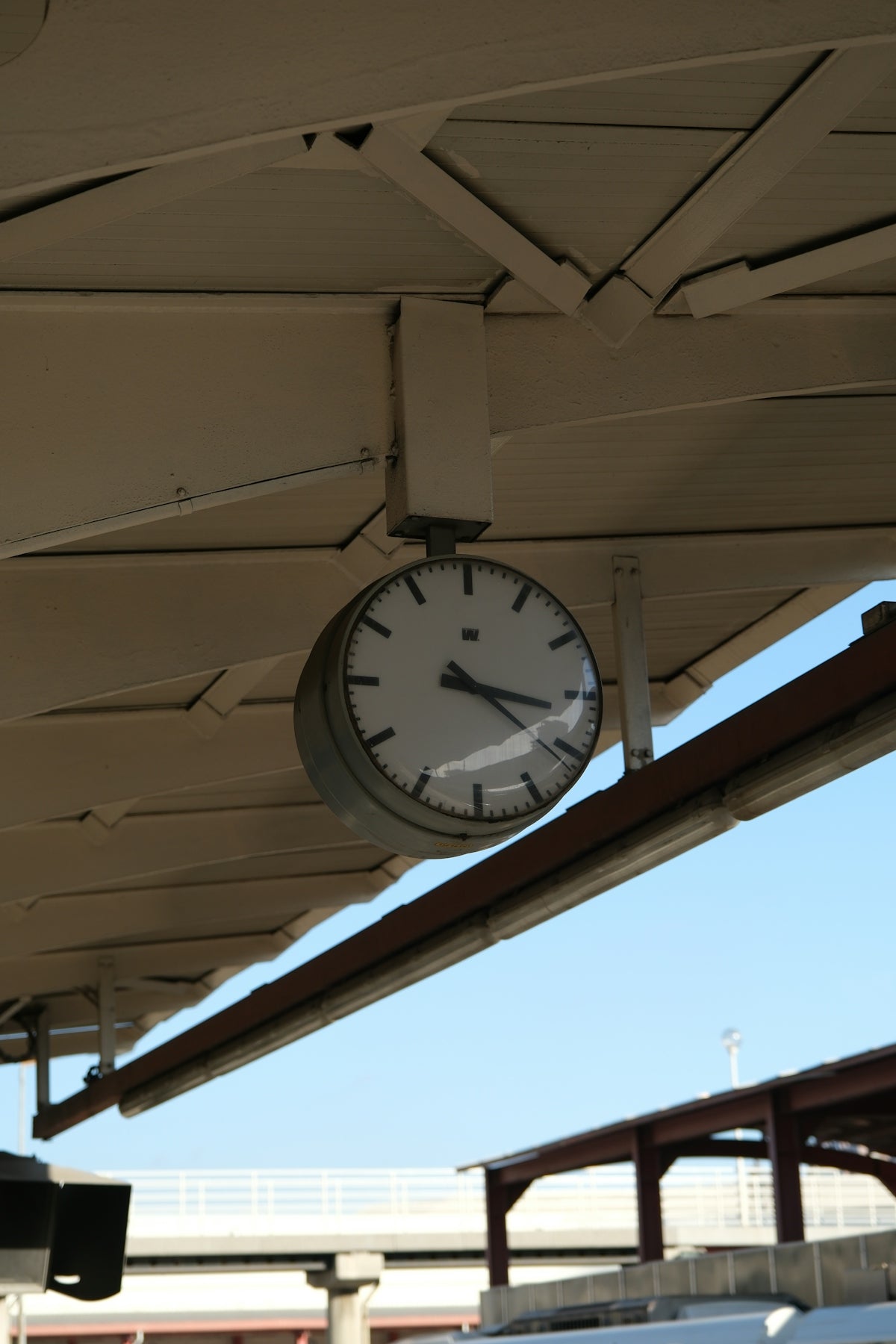 A round clock hangs under a canopy.