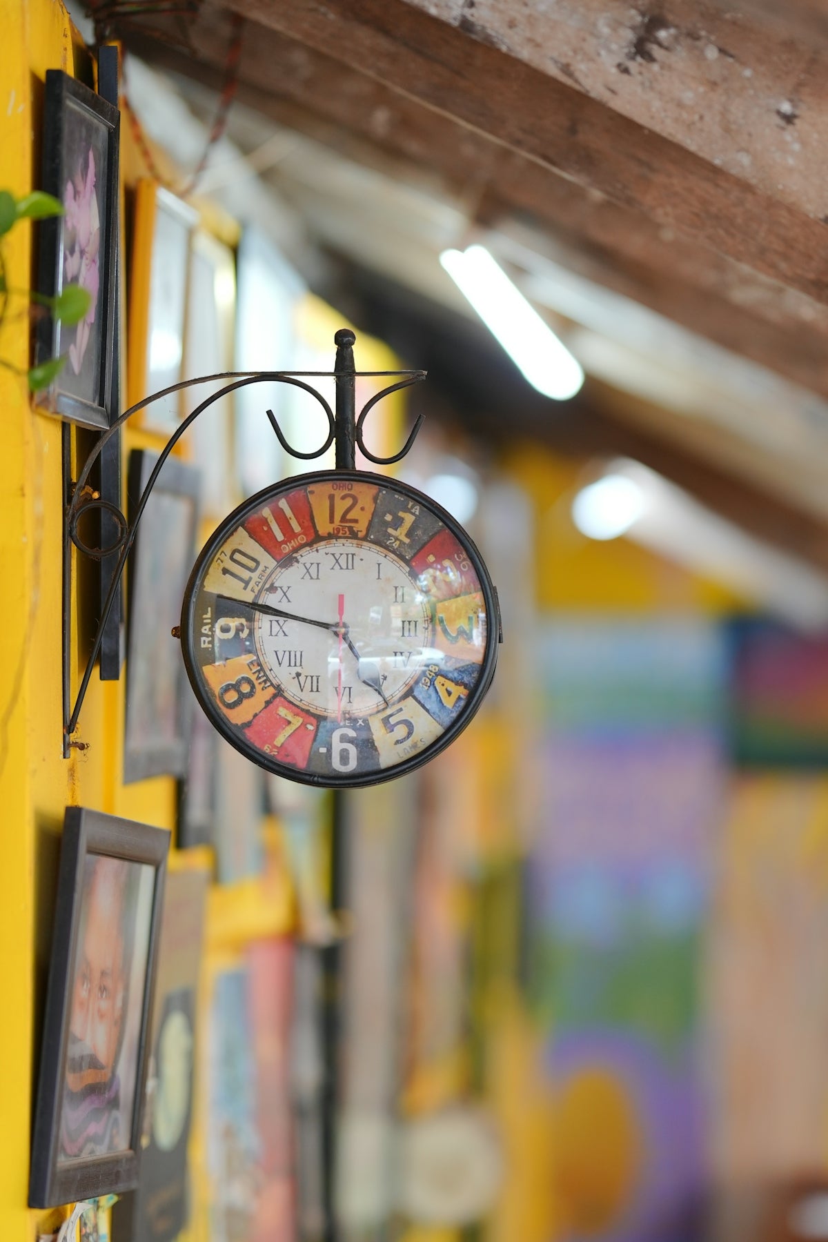 A vintage clock hangs on a yellow wall.