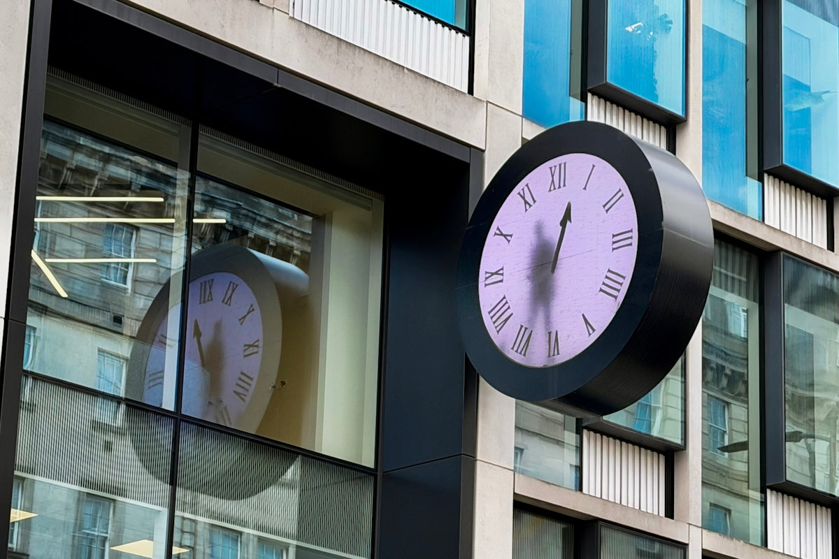 A large clock mounted on a modern building