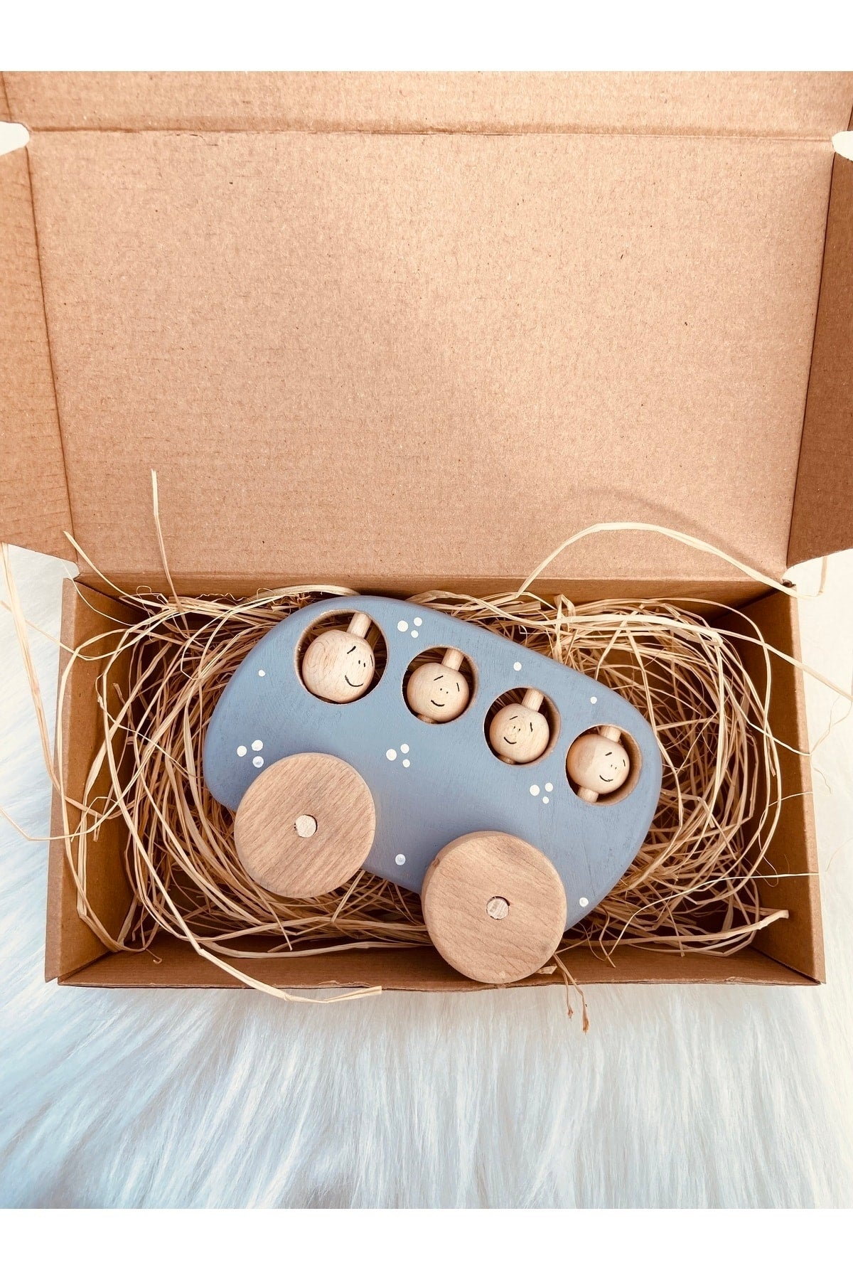 Spielzeugauto aus Holz mit sich drehenden Rädern und beweglichen Passagieren in verschiedenen Farben
