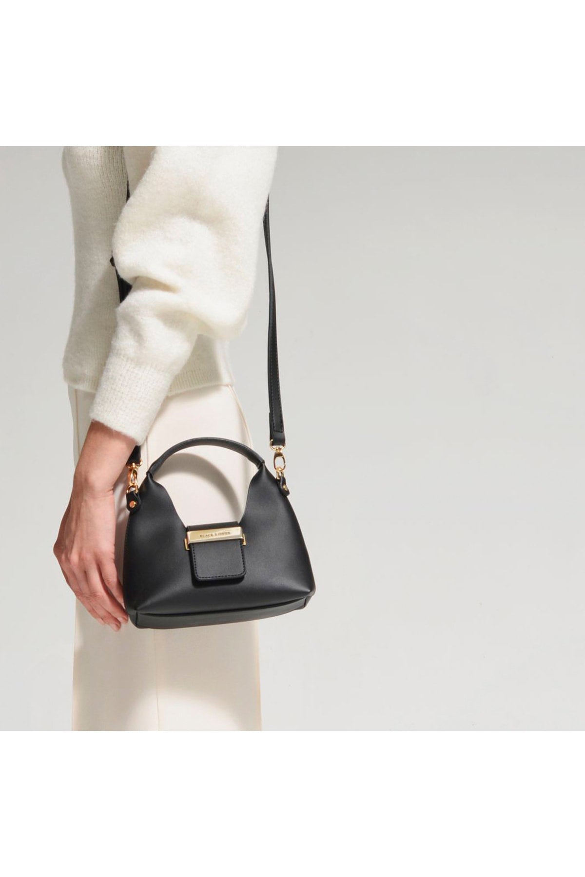 Schwarze Mini-Tasche mit Riemen und Accessoire-Detail